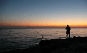 Person fishing at sunset