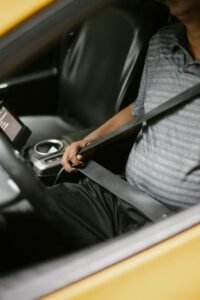 Person in a vehicle putting on seatbelt 