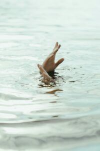 Person underwater with their hands out 