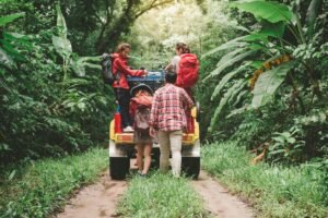 People getting in a car surrounded by trees
